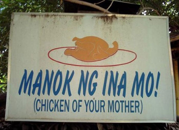 A Filipino sign that reads 'Manok ng ina mo', with an English translation below it which reads 'Chicken of your mother'